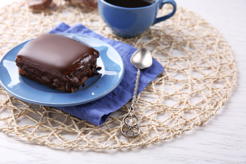 Delicious chocolate brownie on plate on wooden background