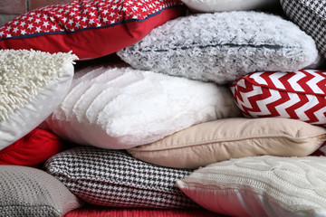 Multicoloured pillows on a brick wall background