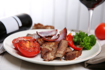 Roasted beef fillet and grilled vegetables on plate, on wooden background