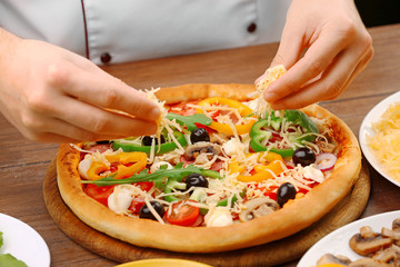 Cook making delicious pizza at the restaurant, close-up