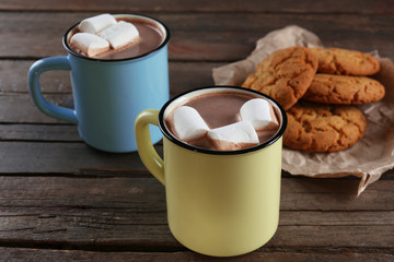 Tasty cocoa and marshmallow in metal old-fashioned mugs on the table