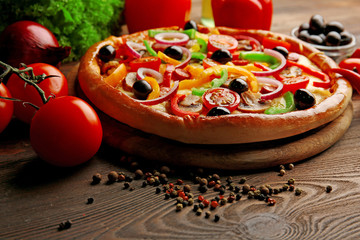 Delicious pizza with vegetables, on wooden table