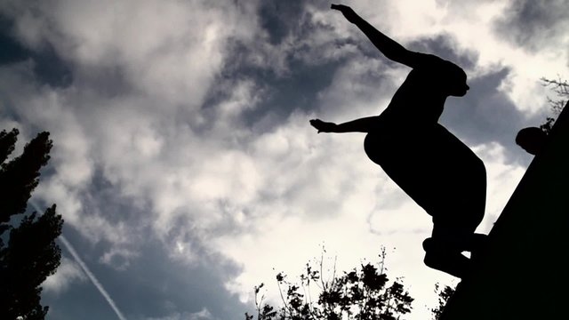 silhouette of parkour jumping man against sky and clouds Slow Motion 400 fps