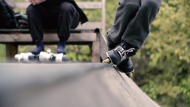 Teen with roller skates performing a stunt on a half pipe ramp Slow Motion 400 fps