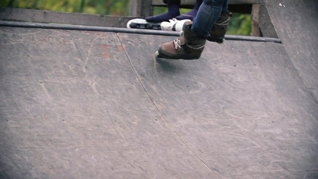 Teen with roller skates performing a stunt on a half pipe ramp Slow Motion 400 fps