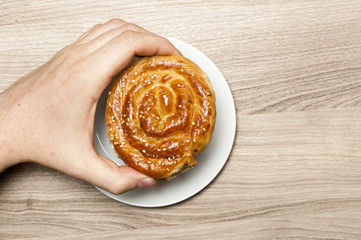 Bun with sesame, in the man`s hand.