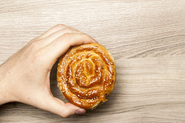 Bun with sesame, in the man`s hand.