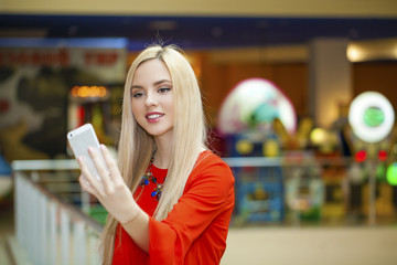 Young beautiful blond woman taking selfie with mobile phone