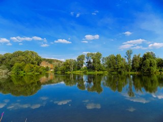 Fototapeta na wymiar Lake with reflexion, trees and sky