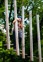 Adventure climbing high wire park - woman on course in mountain