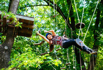 Adventure climbing high wire park - woman on course in mountain