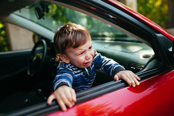 Crying baby boy in car.