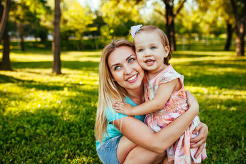 Happy mom and daughter smiling at nature.