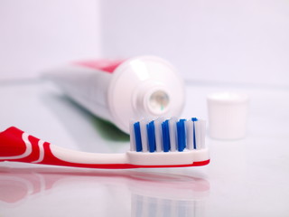 toothbrush on the background of open toothpaste tube, shallow depth of field, closeup
