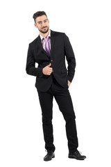 Young bearded successful man in suit with thumbs up smiling at camera.  Full body length portrait isolated over white studio background. 