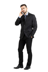 Angry business man on the phone looking at camera. Full body length portrait isolated over white studio background. 