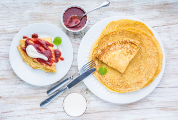 Pancakes with cottage cheese topped with strawberry jam and cream