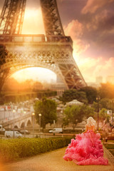 beautiful girl in a pink dress runs on the background Eiffel Tower in Paris