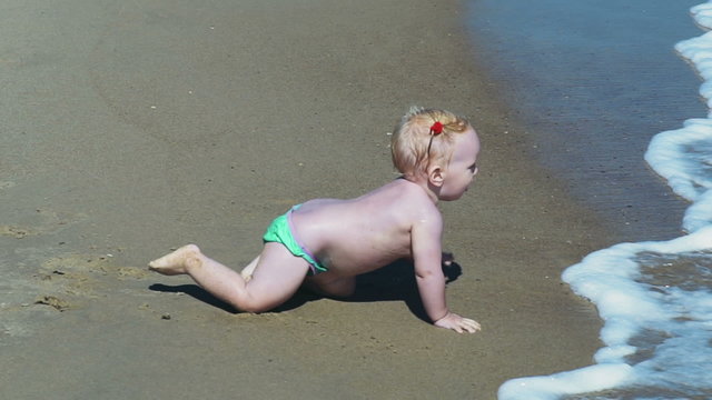 little child exploring the sand and sea waves slow motion