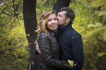 Счастливая влюбленная пара гуляет в парке в солнечный осенний день 