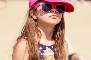 Little girl kid eating ice cream on beach. Summer.