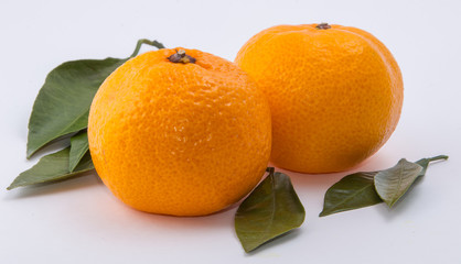 Два изолированных мандарина и листья на белом фоне