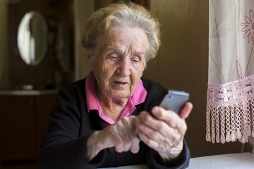 Elderly woman typing on the smartphone.