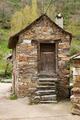 Pequeña casa antigua y tradicional construida en  piedra. Con los peldaños de la escalera de acceso © Siur