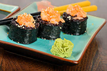 Baked sushi rolls served on blue plate