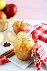 Apple jam in jar on a white wooden table