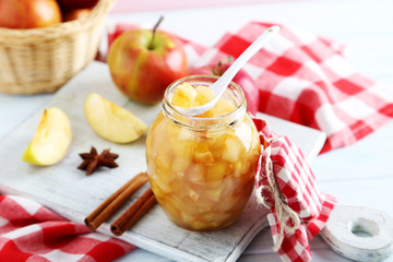 Apple jam in jar on a white wooden table