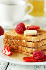 Fresh toast with raspberry and strawberry on white wooden backgr