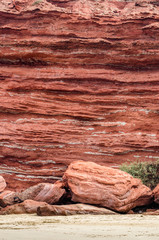 Red wall of rocks on beautiful beach