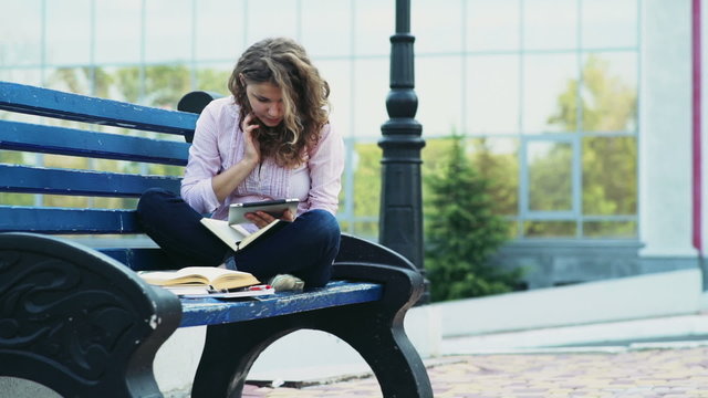 female student sitting on a bench and using tablet slow motion