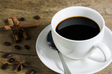 Coffee beans and white coffee cup with cinnamon stick and star a