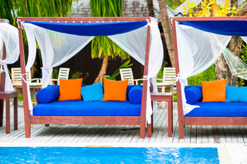 Blue towels on beach beds near swimming pool at tropical resort