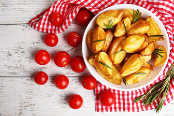 Baked potato wedges on wooden table, closeup