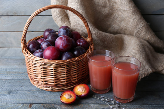 Delicious plum juice with fruits on table close up