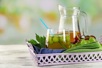 Composition of grape, glass and jug with juice on the server