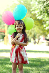 Little girl with balloons in the park