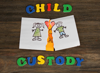 Torn apart drawing of a family on wooden background