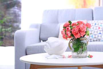 Beautiful rose in vase on table in room