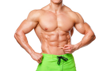 Sexy athletic man showing abdominal muscles without fat, isolated over white background. Muscular...