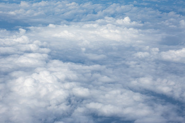 Aerial view on clouds and blue sky from airplane window
