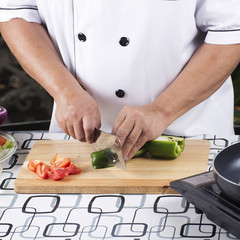 Chef cutting green bell pepper