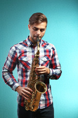Naklejka premium Saxophone player on blue background