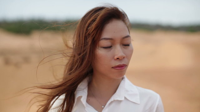 Asian woman serious sad looking outdoor desert wind 