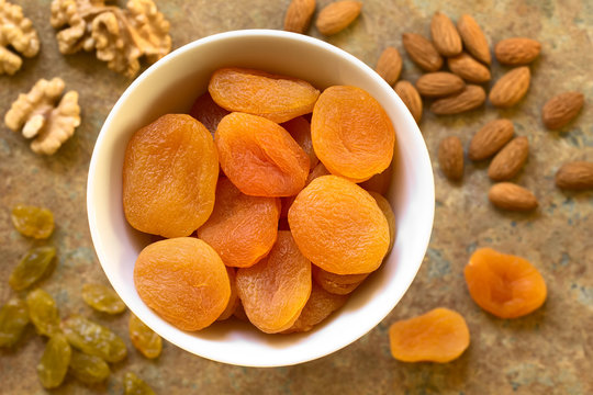 Dried Apricots, A Healthy Snack Containing Vitamins, Beta-carotene, Fiber, Antioxidants, Photographed Overhead On Slate With Natural Light (Selective Focus, Focus On The Apricots On The Top)