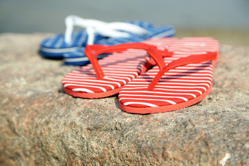 Bright flip-flops on stone, nature background