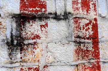 Red and black strokes on a white brick wall